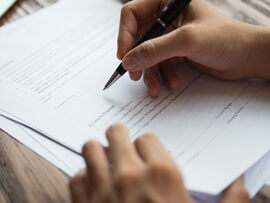 close-up of a person writing on an invoice