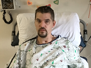 Bryan off of ventilator and sitting upright in bed.