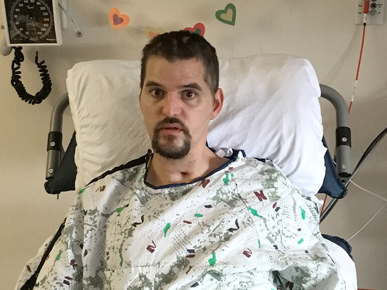 Bryan off of ventilator and sitting upright in bed.