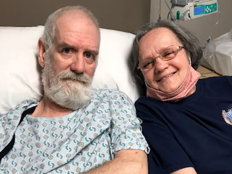 Kenneth sits with his wife Joyce on his hospital bed.