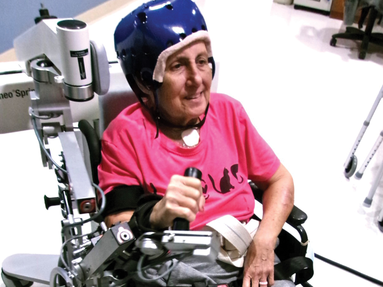 At UF Health Rehabilitation Hospital, Debbie participated in intensive therapy to regain her independence. Here, Debbie uses a specialized robotic arm to help regain movement from in her arm and hand.