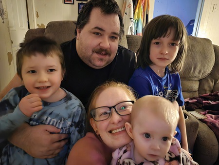 Matthew and family smiling at the camera.