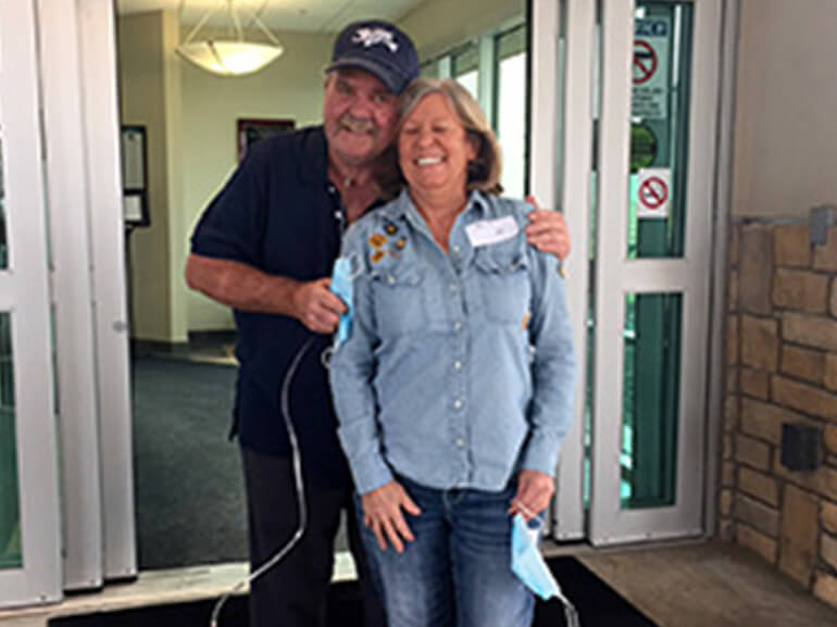 Tommie hugging his wife outside of the front doors of the hospital. 