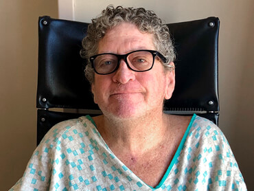 Paul sitting upright unassisted after two months in hospital and successful liberation from ventilator.