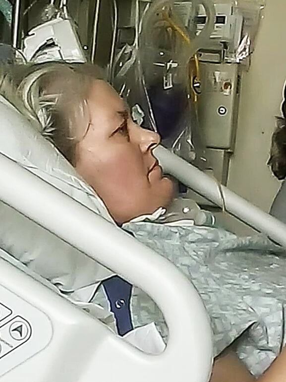 Angela Fawley laying in a hospital bed.