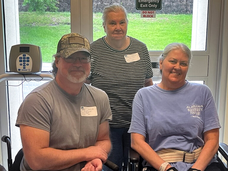Angela Fawley, sitting in a wheel chair, next to her family.