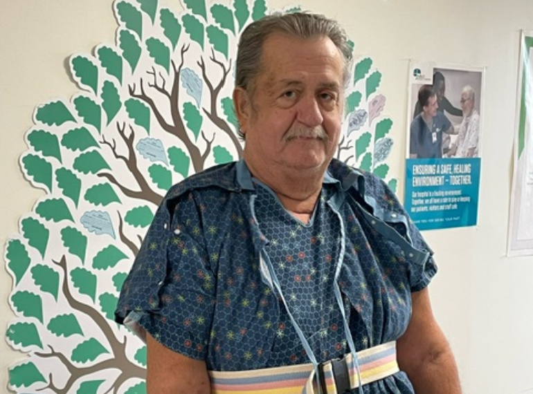 Man in hospital hallway looking at camera