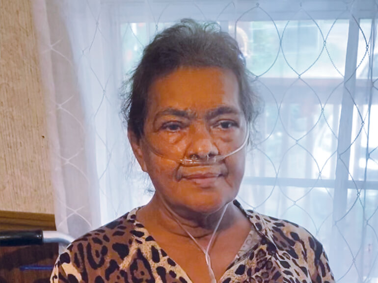 Epifana smiling in her home.