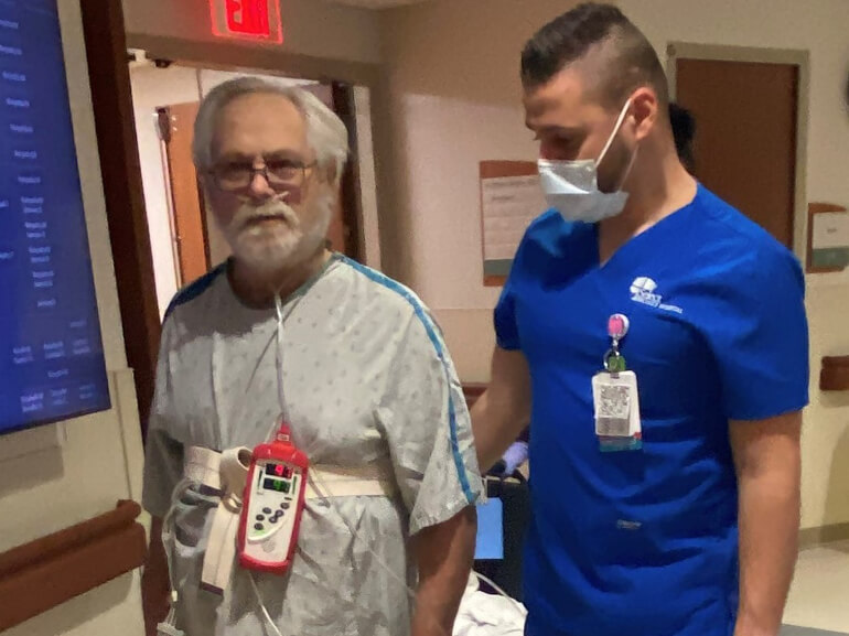 Kenneth Walker walks down the hall with his therapist. 