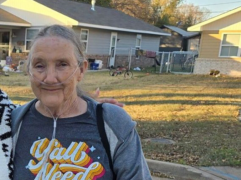 Close up of Loretta walking outside her house.