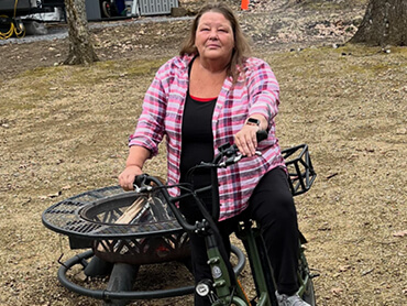 Peggy Downey stands with her bike following her recovery.