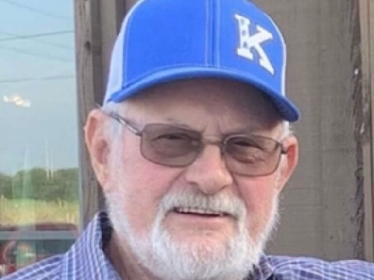 Ronald smiling in a baseball cap.