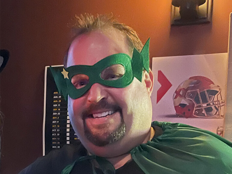Scott smiling in a green superman eye mask.
